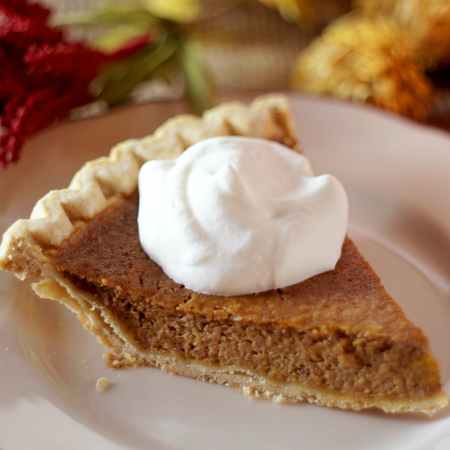 close up photo of pumpkin pie with whipped cream